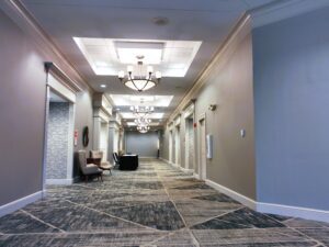 A hallway with many lights and chairs in it