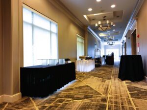 A long hallway with tables and chairs in it