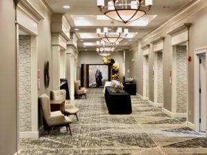 A hallway with chairs and tables in it