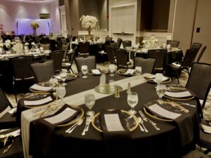 A banquet hall with tables and chairs set up for dinner.