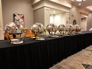 A long table with many silver bowls on it