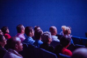 A group of people sitting in rows on seats.