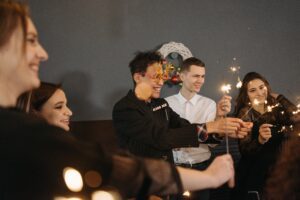 A group of people holding sparklers and laughing.