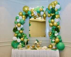 A beautiful decoration on a table with balloons surrounding a mirror