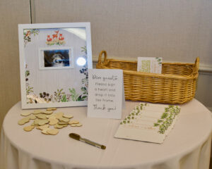 A closeup look at a table with a photograph, a basket and card on it.