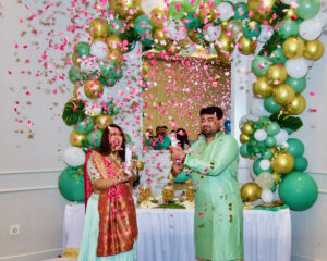 A man and a woman standing and celebrating with confetti.